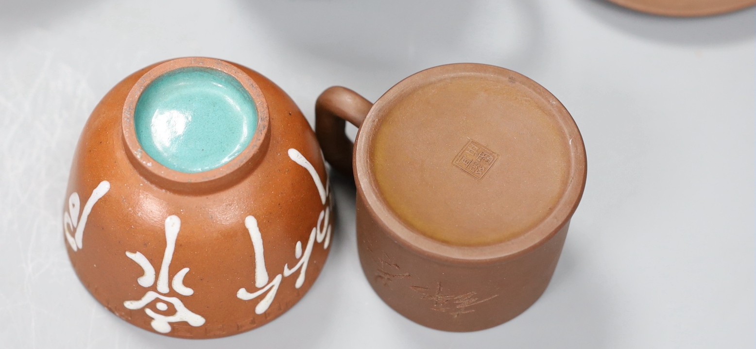 A 19th century Chinese Yixing cup, two later teapots and a cup and saucer